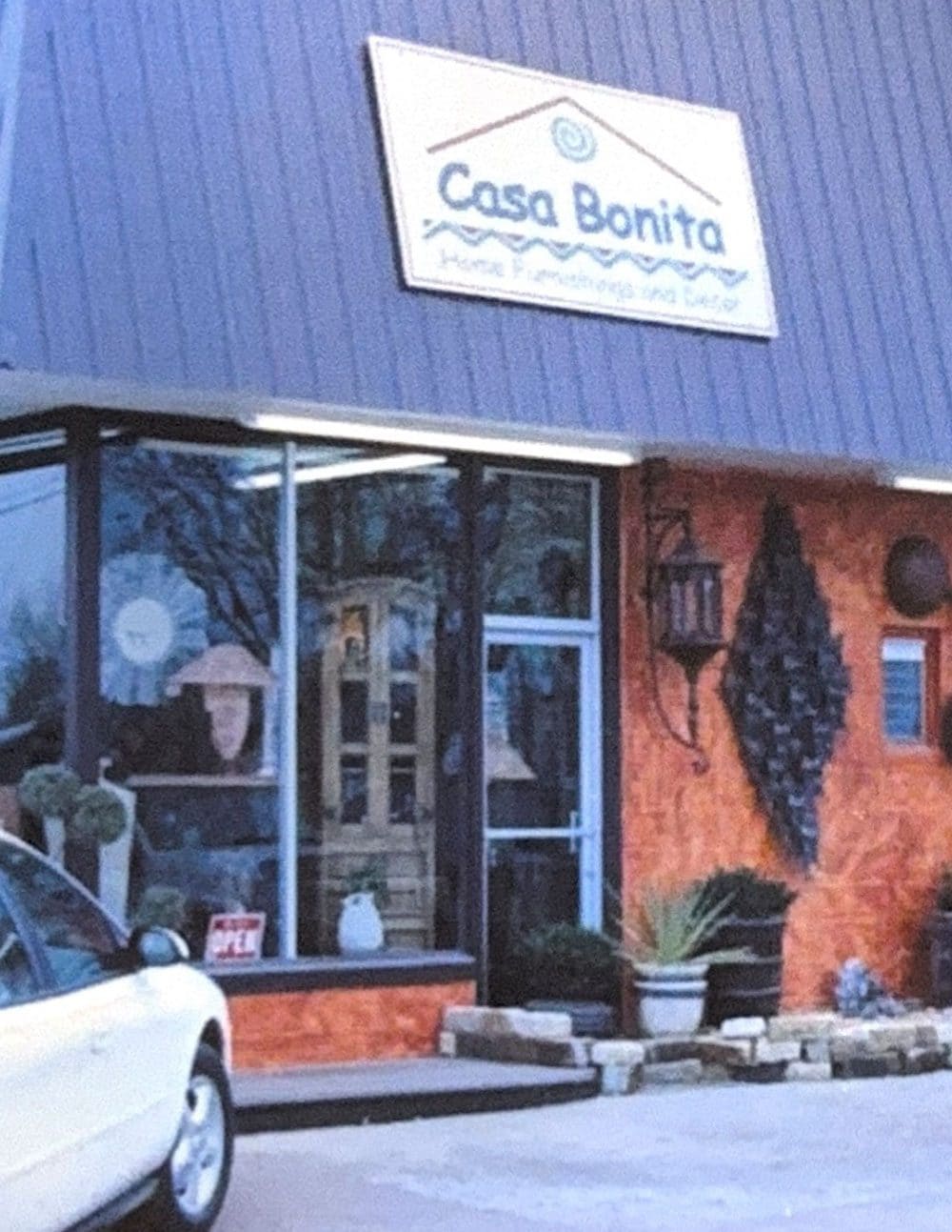 The Casa Bonita storefront with its painted sign, furniture and decor visible through the windows