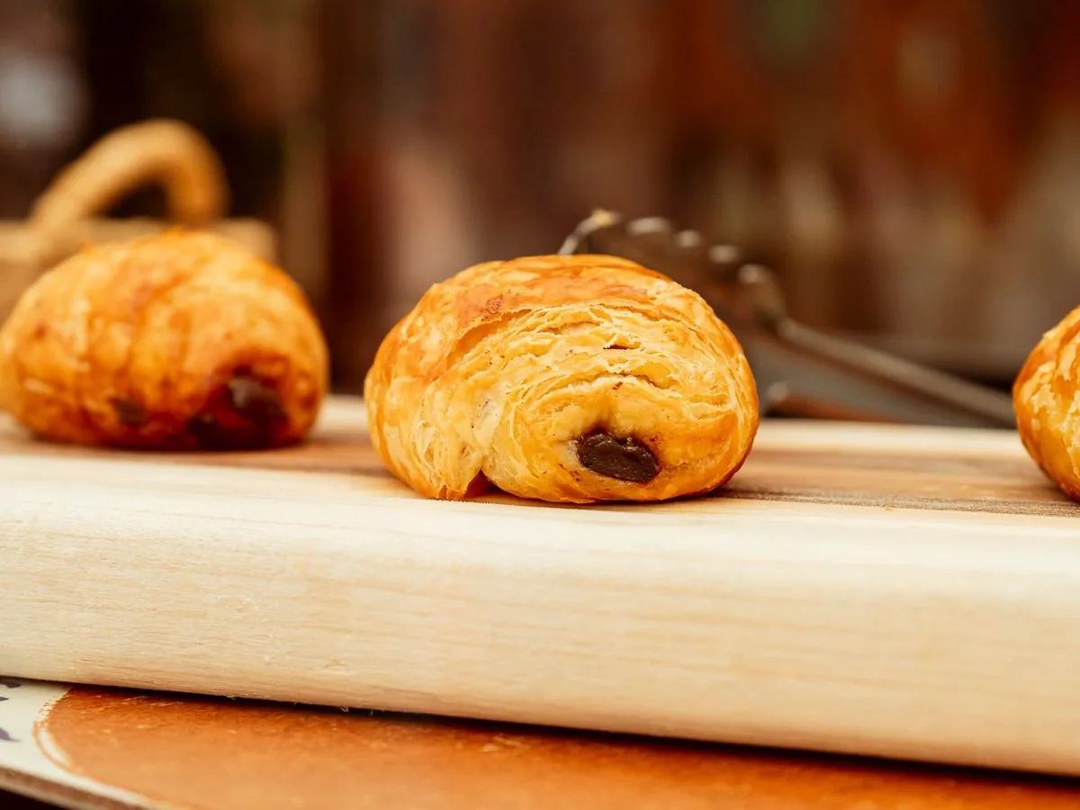 Chocolate croissants on a wooden board at the Chalala counter
