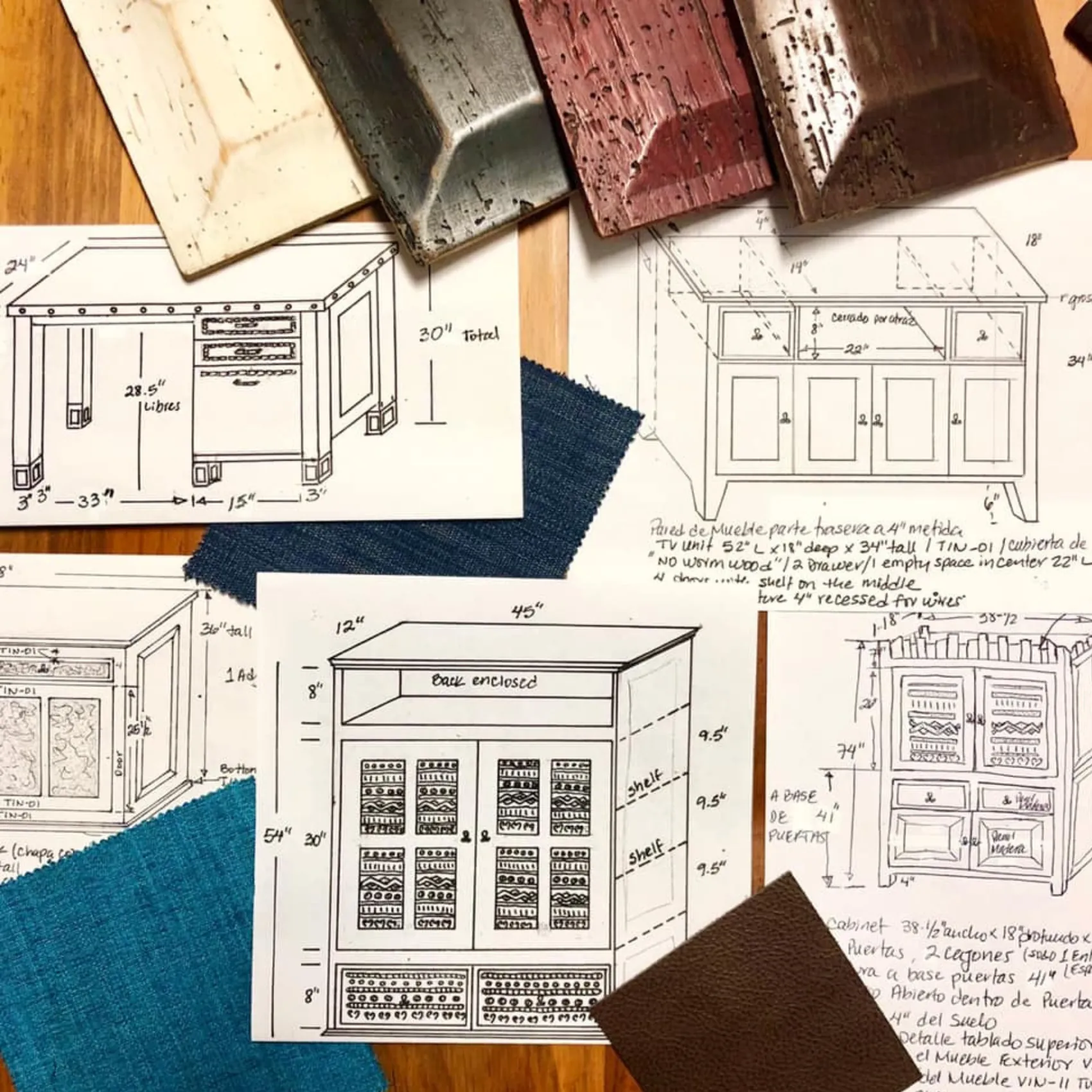 Hand-drawn buffet and cabinet plans with measurements, laid out under wood finish boards and squares of blue and brown upholstery fabric