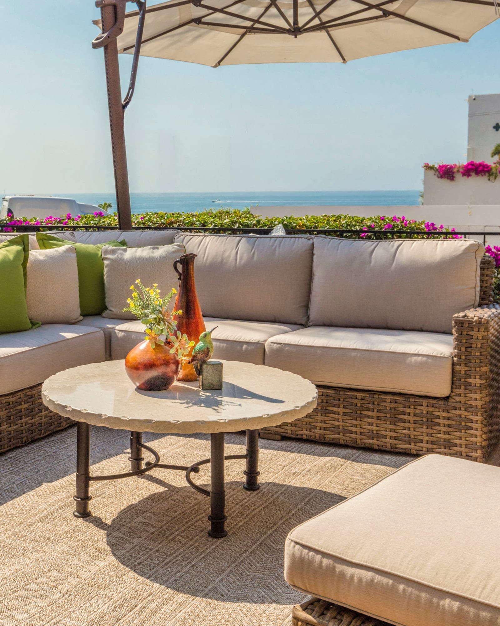 Casa Bonita outdoor showroom terrace with a woven sectional, cushions and hand-thrown pottery above the sea
