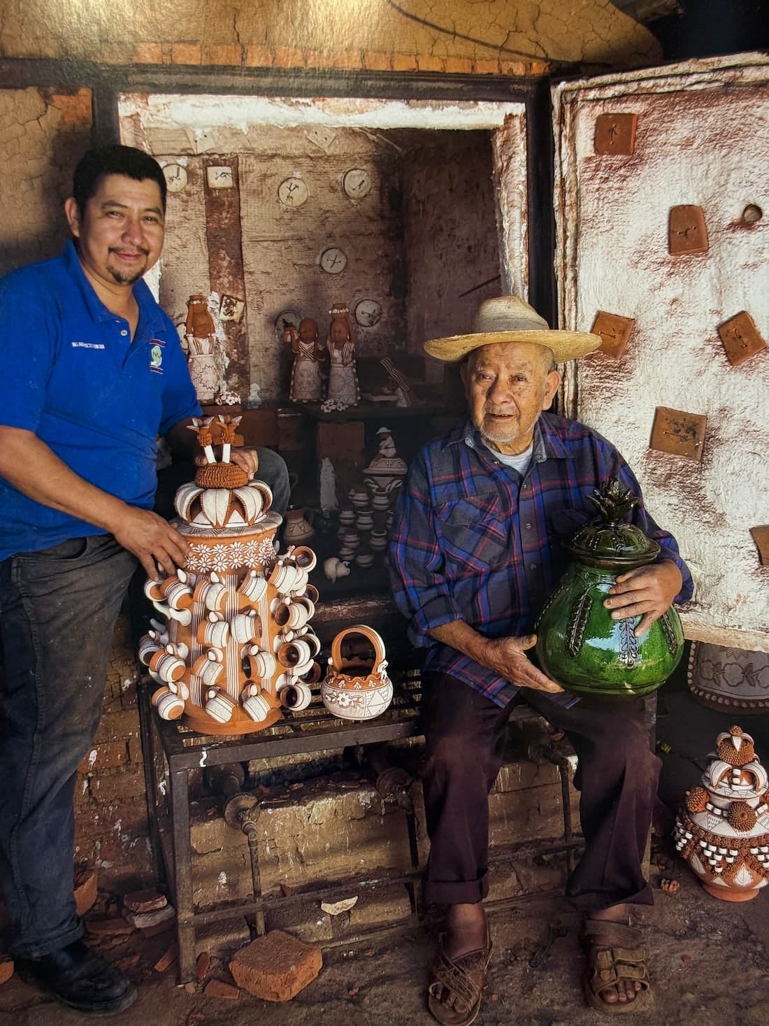 Two Patambán potters in their workshop, holding a tiered piña vessel and a green glazed jar
