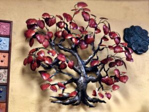 Metal wall art of a tree with red leaves, sold in Cabo San Lucas
