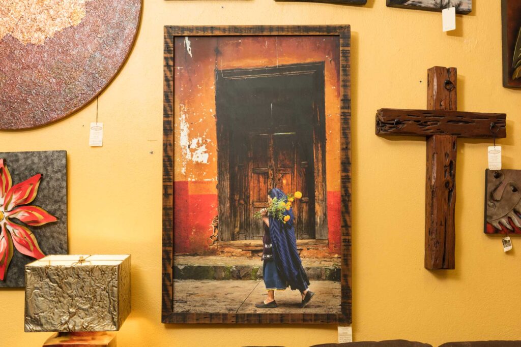 Bruce Herman Al Panteon Bruce Herman photograph of woman carrying flowers in front of a colorful wall and door