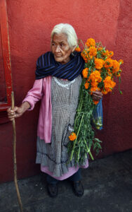 Bruce Herman photograph of elderly Mexican woman holding orange flowers