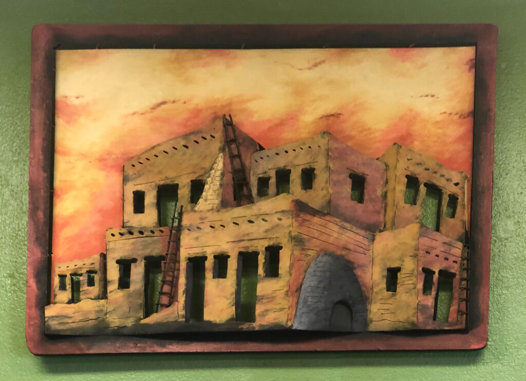 126DF532-99B9-4EFD-8CC2-C2BAA5622122 Metal wall art of a building at sunset