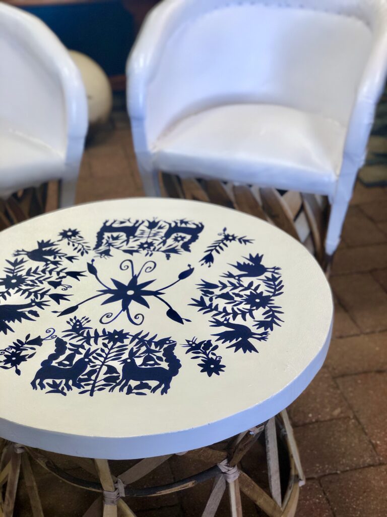 Equipal-Style Table with Handpainted Details White Mexican equipal table with blue handpainted details in Cabo San Lucas, Mexico