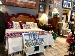 Queen bed with Mexican handwoven bedspread, pillows, and a runner