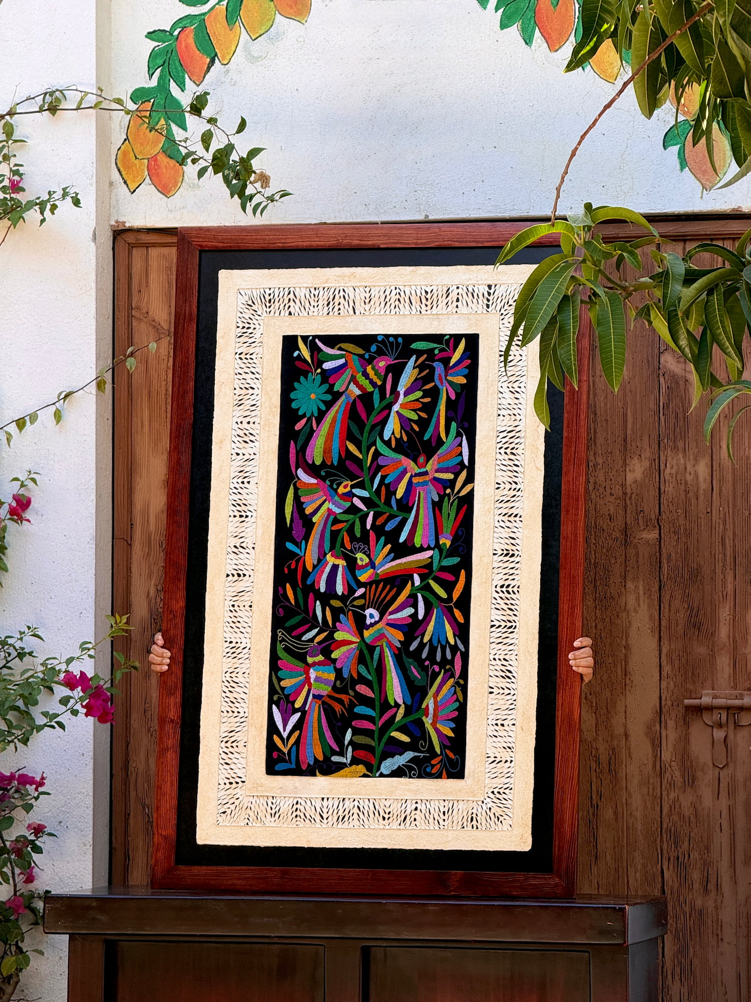 Framed wall hanging featuring traditional amate art